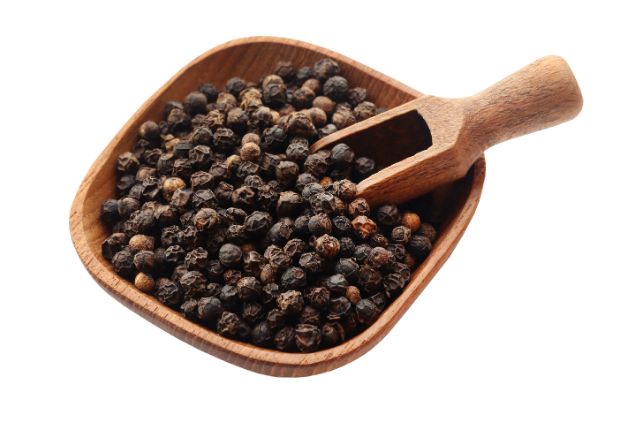 Golden turmeric powder with black peppercorns for natural wellness